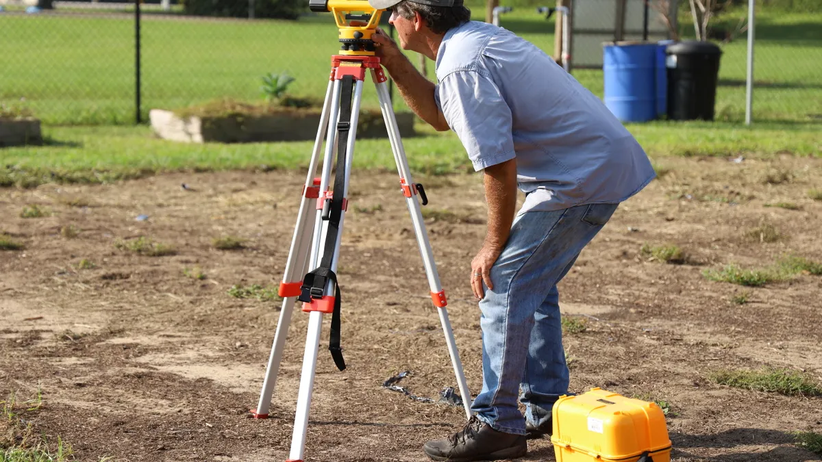 Man using a surveying instrument on a tripod
